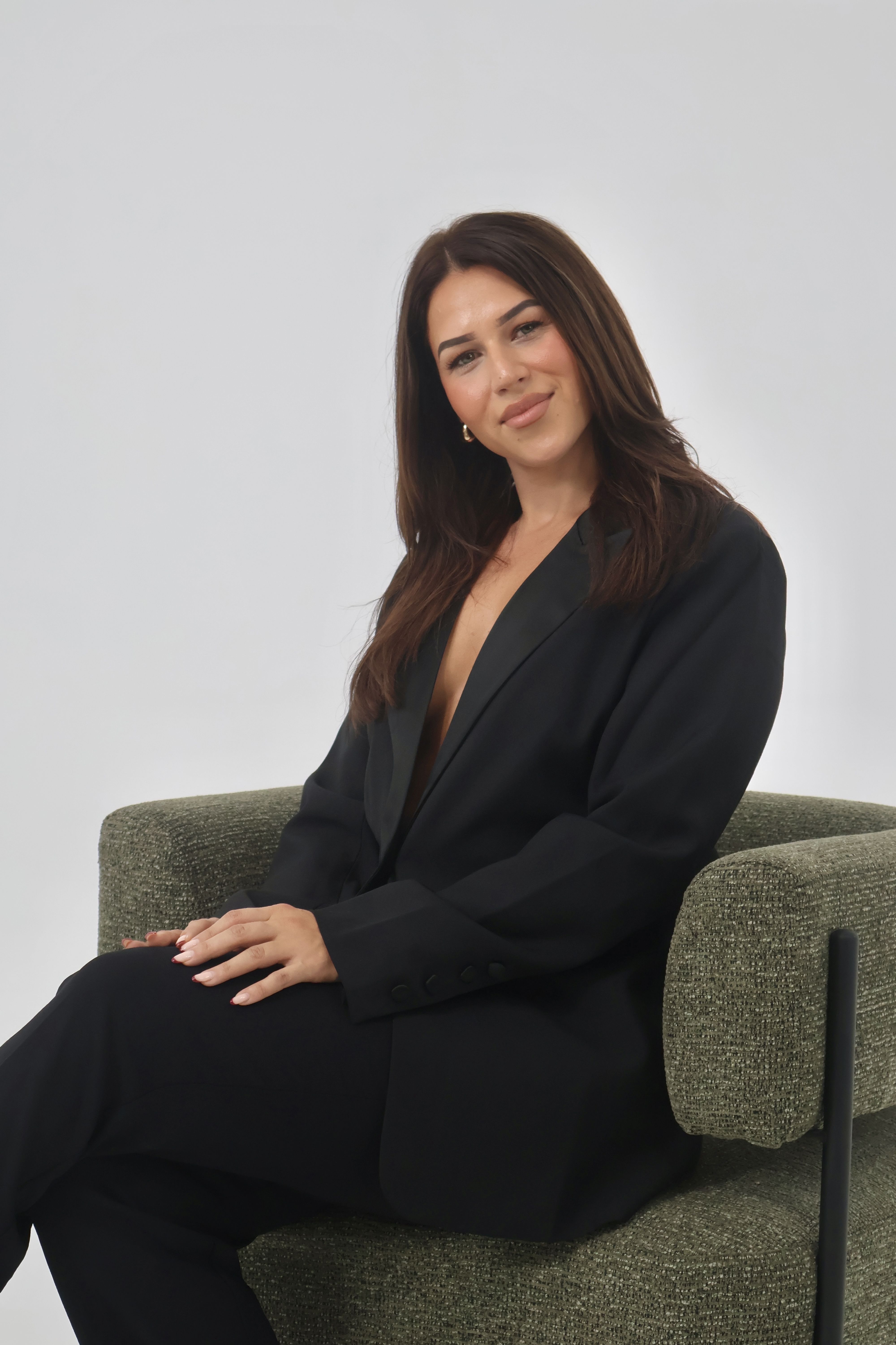Bec, founder of Bhava Beauty, seated in the studio