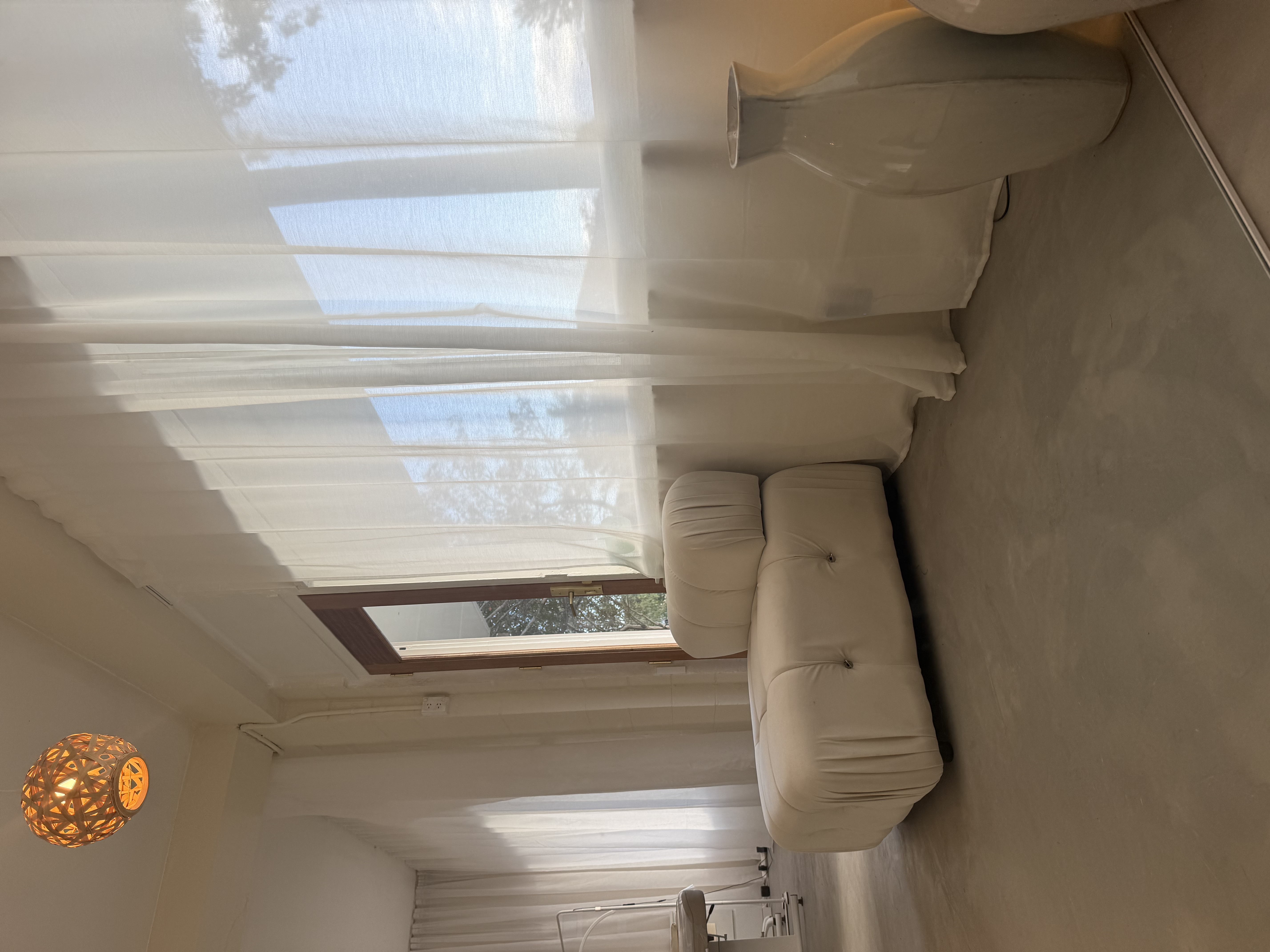 Cream sofa and rattan pendant light in the Bhava Beauty studio